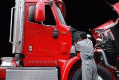 Mechanic working on a red truck engine